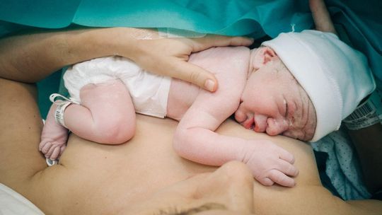 zdjęcie przedstawia noworodka na brzuchu