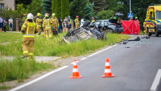samochód w rowie, wokoło strażacy i policjanci