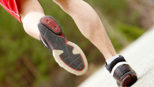 Powrót do aktywności fizycznej po świętach. Jak bezpiecznie to zrobić? zdjęcie przedstawia buty na nogach biegnącej osoby