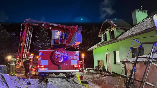 zdjęcie przedstawia samochód straży pożarnej przed domem