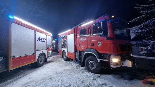Samochody bojowe straży pożarnej stojące na drodze pokrytej śniegiem