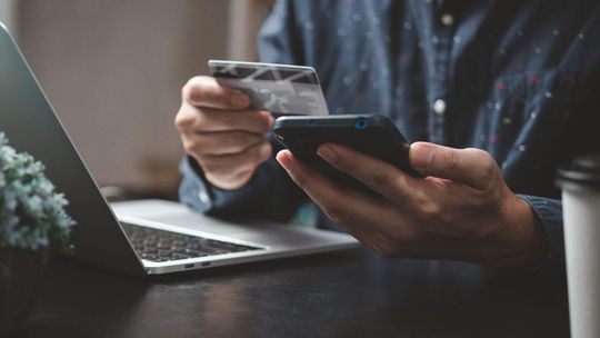 mężczyzna trzymający telefon i kartę