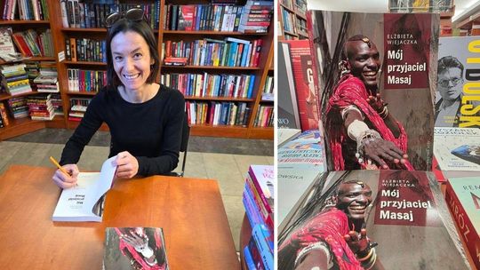 zdjęcie przedstawia kobietę uśmiechającą się do obiektywu, podpisującą książkę