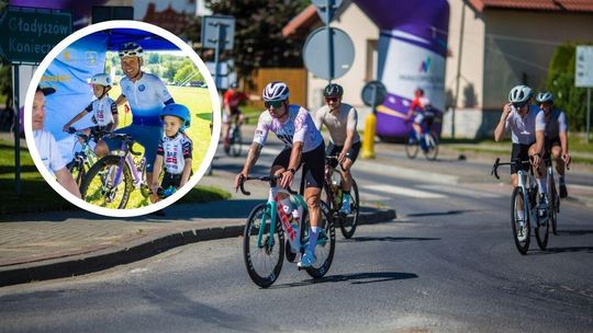 zdjęcie przedstawia grupę kolarzy jadących jezdnią
