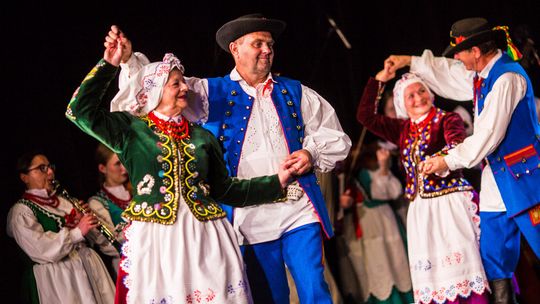 zdjęcie przedstawia parę w stroju ludowym podczas tańca na scenie