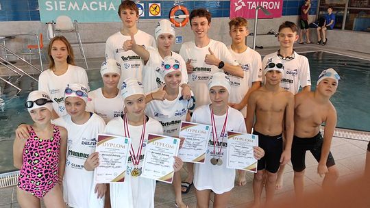 dzieci z dyplomami w ręce na brzegu basenu pływackiego w Krakowie