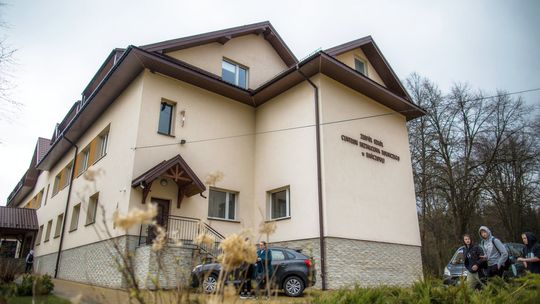 zdjęcie przedstawia duży budynek szkoły, przed nim uczniowie