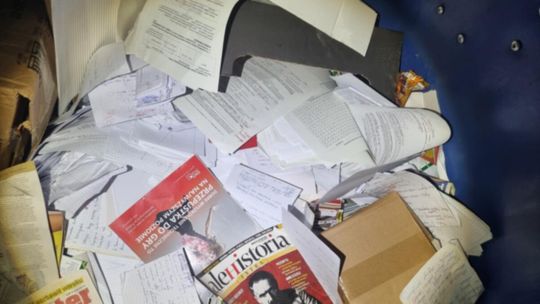 zdjęcie przedstawia kartki papieru i kartony w śmietniku