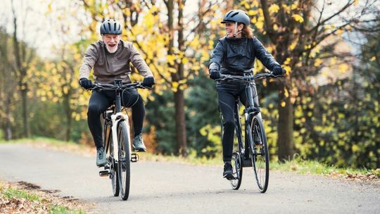 Para starszych osób czerpie przyjemność z jazdy na rowerach elektrycznych w parku Iwobike.pl