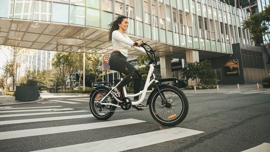 zdjęcie przedstawia kobietę jadącą na rowerze elektrycznym