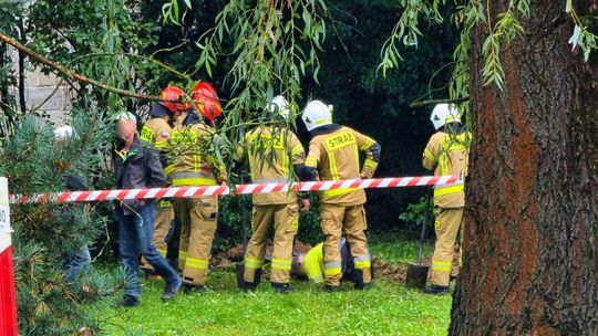 strażacy nad wykopem w którym pracuje mężczyzna