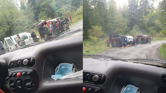 ludzie stojący przy samochodzie w środku lasu