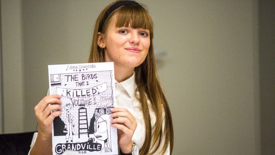 zdjęcie przedstawia dziewczynę z komiksem przed sobą