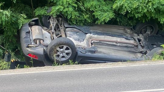 Zdjęcie przedstawia Samochody stojące w korku i samochód w rowie