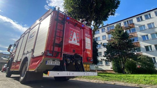 Wóż straży pożarnej na jezdni na tle bloku