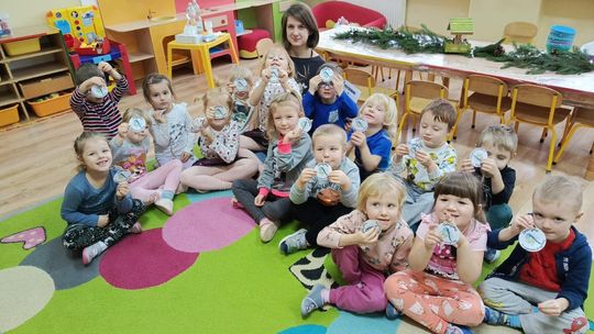 Przedszkolaki z wychowawczynią, siedzą na dywanie