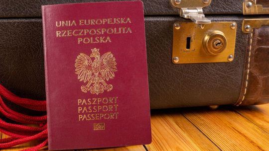 paszport z orłem, w tle brązowa walizka
