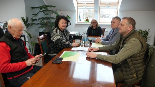 zdjęcie przedstawia dorosłe osoby siedzące przy stole