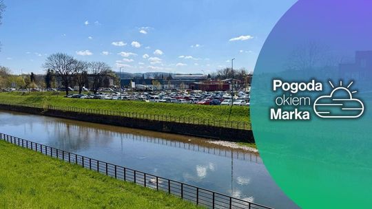 zdjęcie przedstawia rzekę za nią parking pełen samochodów