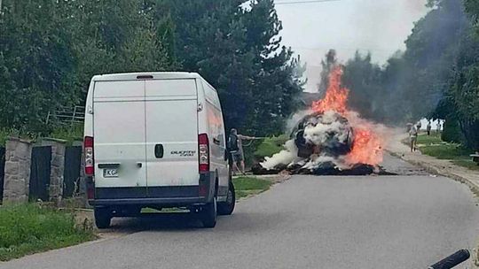 palący się traktor z naczepą pełną słomy w staszkówce