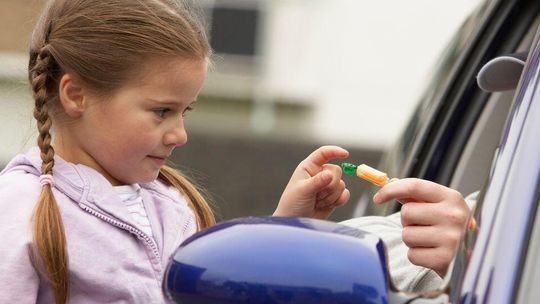 zdjęcie przedstawia dziewczynkę zabierającą cukierka