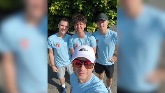 zdjęcie przedstawia kilku mężczyzn w niebieskich koszulkach robiących sobie selfie