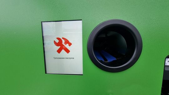 zdjęcie przedstawia zieloną maszynę do oddawania butelek