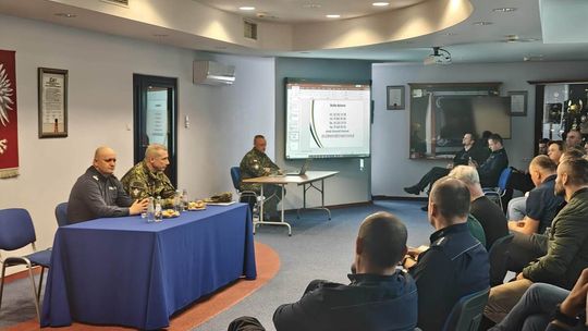 zdjęcie przedstawia policjantów i służby straży granicznej w budynku