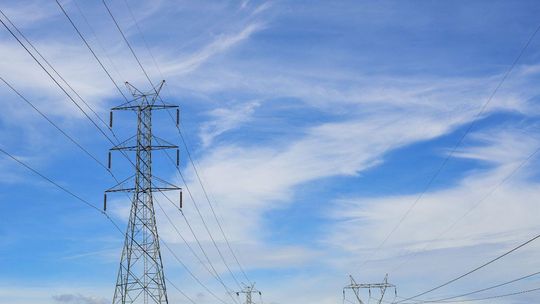 zdjęcie przedstawia słup energetyczny i linie wysokiego napięcia