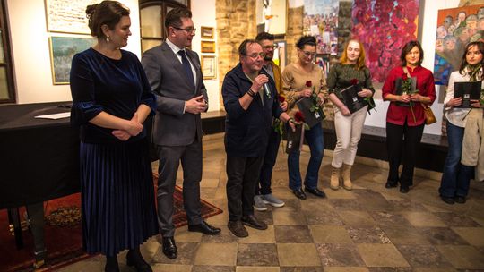 zdjęcie przedstawia grupę osób z różami w galerii sztuki w Gorlicach