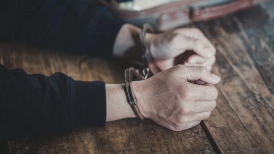 Zdjęcie przedstawia dłonie w kajdankach