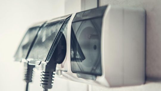zdjęcie przedstawia gniazdko elektryczne i wpięte do niego wtyczki