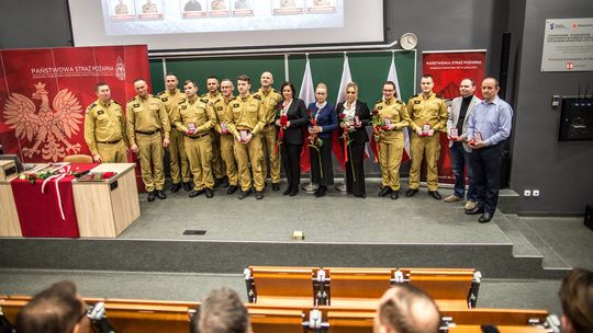 zdjęcie przedstawia grupę osób w mundurach strażackich na scenie