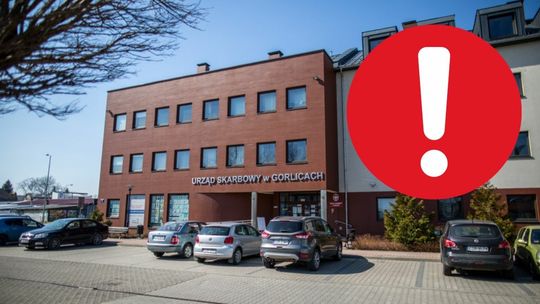 budynek urzędu skarbowego w Gorlicach, na pierwszym tle graficzny znak wykrzyknika na czerwonym tle