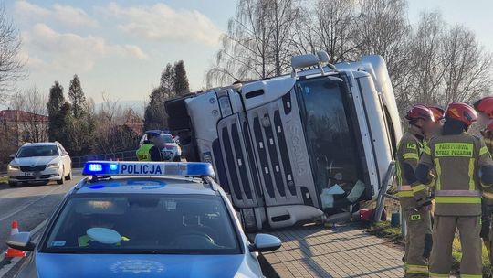zdjęcie przedstawia strażaków stojących obok ciężarówki, na pierwszym planie radiowóz