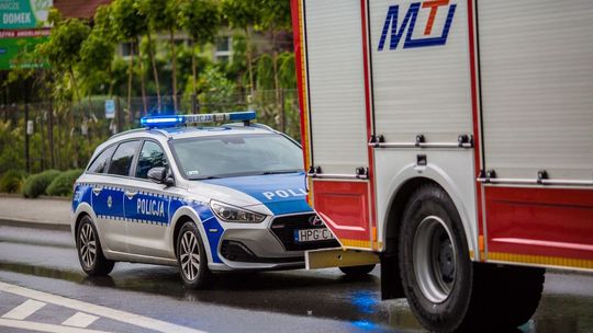 zdjęcie przedstawia policyjny radiowóz stojący za samochodem straży pożarnej