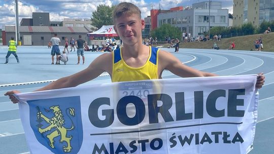 chłopak trzymający flagę z napisem gorlice miasto światła