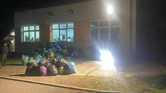 zdjęcie przedstawia poukładane worki przed budynkiem