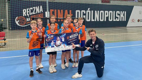 zdjęcie przedstawia dzieci z trenerem piłki ręcznej