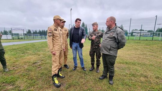 zdjęcie przedstawia mężczyzn na brzegu rzeki