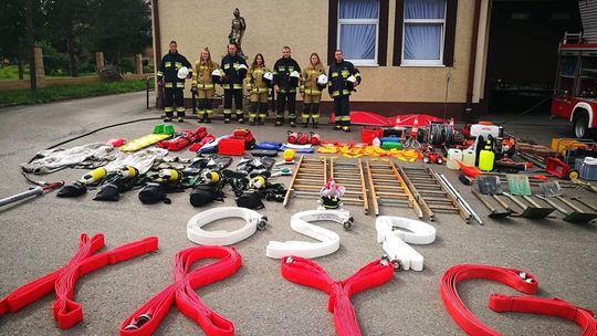 zdjęcie przedstawia strażaków przed remizą