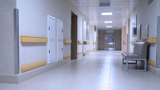 wnętrze korytarza, po bokach drzwi i kanapa do siedzenia