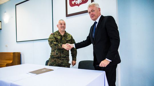 zdjęcie przedstawia dwóch mężczyzn podających sobie dłonie