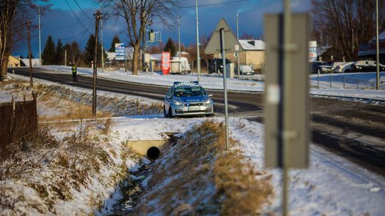 zdjęcie może przedstawiać policyjny radiowóz stojący na poboczu zaśnieżonej drogi