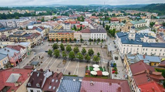 rynek miasta w gorlicach, widok z drona, widać plac z drzewami, wokoło kamieniczki
