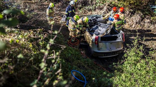 samochód w potoku, wokół niego strażacy