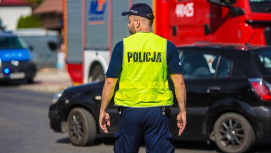 policjant stojący tyłem kierujący ruchem