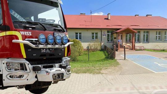zdjęcie przedstawia samochód straży pożarnej przed budynkiem