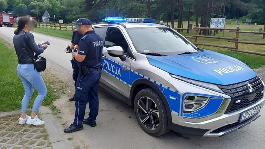 kobieta z policjantami przy radiowozie
