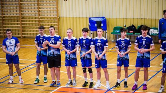 zdjęcie przedstawia chłopców stojących w rzędzie w koszulkach sportowych w hali sportowej